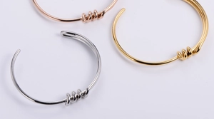 Detailed top view of minimalist knotted knot bracelets in gold, silver, and rose gold finishes
