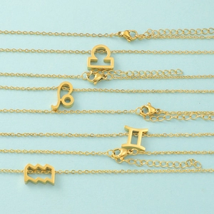Gold-plated minimalist zodiac sign necklace set on light blue background, celestial style