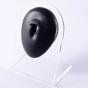 Detail of a black silicone piercing model with a transparent acrylic display stand