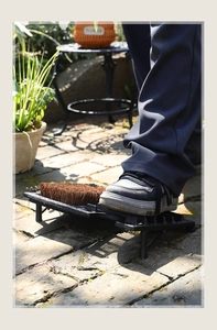 Detail of outdoor cast iron shoe scraper with sturdy fiber bristles for cleaning mud