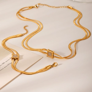 Double layered gold snake chain necklace with square diamond pendant and matching bracelet
