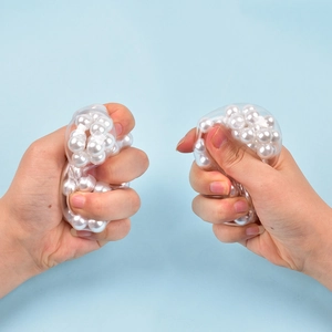 Detailed view of clear stress relief toy being squeezed with white beads inside
