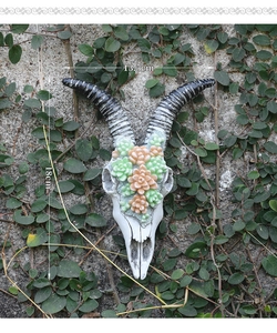 Detailed resin goat skull wall decor with succulents on a stone garden wall, 18cm height