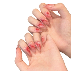 Handmade stiletto press-on nails with red marble gradient design on translucent base