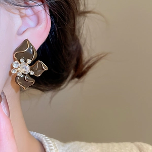 Close-up of vintage flower stud earring with brown enamel and sparkling crystals