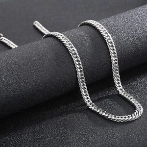 Close-up of a silver titanium steel curb chain necklace with high-gloss metallic finish