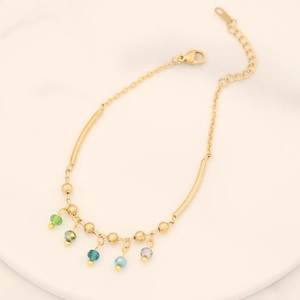 Bracelet doré en acier inoxydable avec perles en cristal facetté sur un plateau