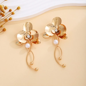Detailed macro shot of vintage gold flower earrings with elegant pearls and crystal accents