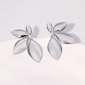 Minimalist silver leaf stud earrings in polished stainless steel on white background