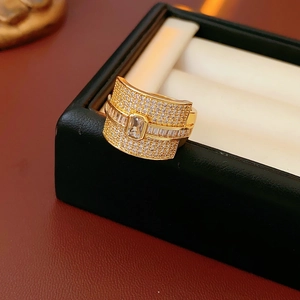 Detailed close-up of a wide gold ring with square cubic zirconia and pave stones