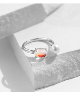 Detail of silver S925 ring featuring a round pearl and iridescent colorful gemstone