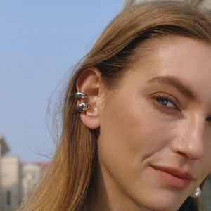 Polished silver stainless steel ear cuffs for non-pierced ears shown on a model outdoors