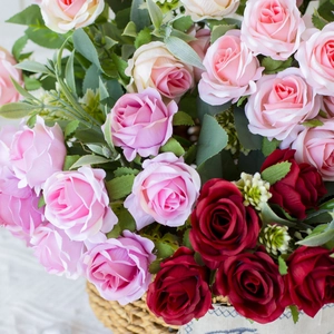 Close-up of pink and red silk roses in a woven basket for wedding decoration