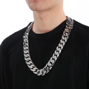 Close-up of 24mm wide polished silver Cuban chain necklace worn by a male model