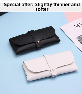 Close-up of thin black and beige faux leather glasses pouches with buckle and lychee texture