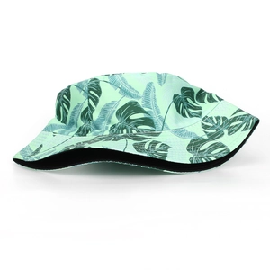 Détail de l'imprimé feuilles tropicales sur un chapeau bob vert en tissu de qualité