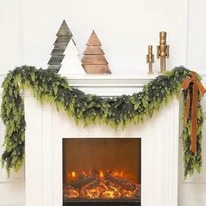 Realistic cedar Christmas garland with brown velvet bow on a white fireplace mantel