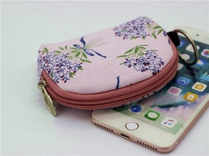 Mini floral coin purse on smartphone showing compact size and fabric texture