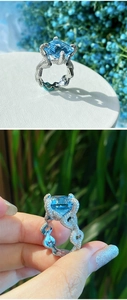Macro detail of aquamarine-blue rectangular gem with diamond-encrusted twisted band