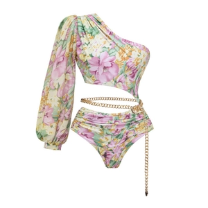 Detail of floral long sleeve one-piece swimsuit with waist cutout and gold chain belt