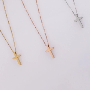 Detailed view of polished cross pendants in gold, silver, and rose gold on O-chains