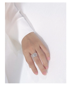 Close-up of a silver wide ring with woven hollow texture on a person's finger