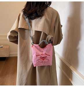 Pink nylon crossbody bag detail with cherry embroidery and checkered rope shoulder strap