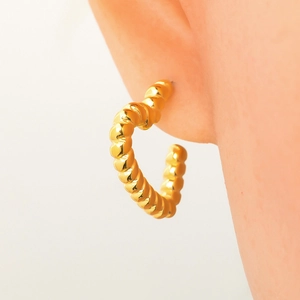 Polished 18k gold plated titanium steel twisted C-shape hoop earrings on model