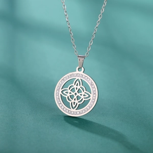 Détail du pendentif nœud de sorcière en argent avec zircons brillants sur tissu bleu
