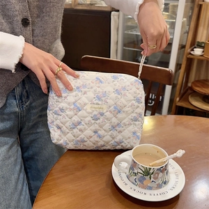 Détail de la trousse de maquillage en coton matelassé blanc avec motif ours et zip
