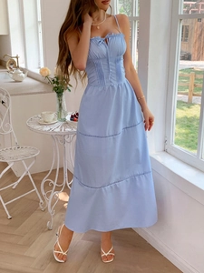 Close-up of light blue sundress featuring smocked bodice, tie details, and lace hem