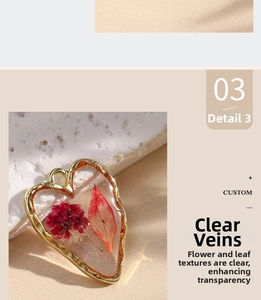 Close-up of heart-shaped resin pendant with dried purple flowers and gold metal frame