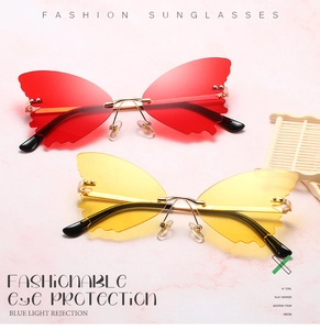 Close-up of butterfly rimless sunglasses with gold metal temples on pink marble