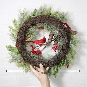 Weihnachtskranz mit Kardinalvogel, roten Beeren und Tannennadeln auf natürlicher Rebe