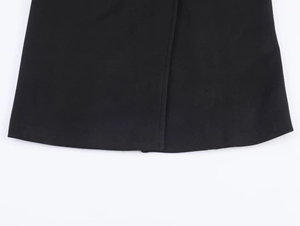 Close-up of black wool coat hem showing high-quality stitching and soft fabric texture