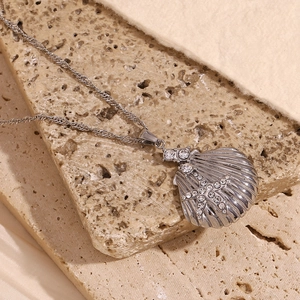 Macro shot of silver shell pendant with rhinestone starfish on a twisted rope chain