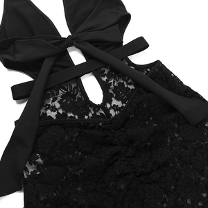 Detailed close-up of intricate floral lace patterns and strap design on a black bodysuit