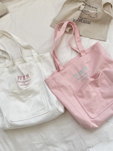 White and pink canvas tote bags with embroidered bows and a convenient front pocket