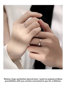 Close-up of Mobius twist sterling silver couple rings worn on hand for engagement