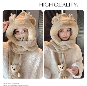 Détail de l'écharpe à capuche en peluche beige avec oreilles de cerf et pendentif ours