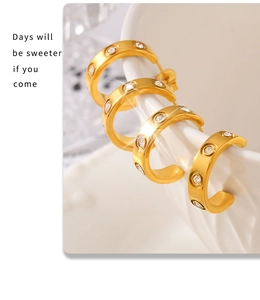 Close-up of C-shaped 18K gold-plated hoop earrings with sparkling cubic zirconia on ceramic