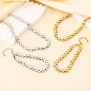 Detailed set of gold and silver watch-strap style necklaces and bracelets on silk