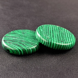 Macro detail of two round malachite crystal stones showing natural green banded patterns