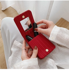 Close-up of red mini lipstick case with built-in mirror and secure metal snap closure