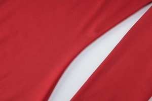Macro view of red knitted fabric with soft texture and white contrast lining detail