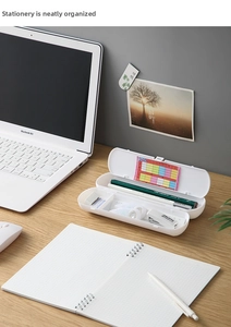 Close-up of a white multi-layer stationery box with organized pencil and ruler storage