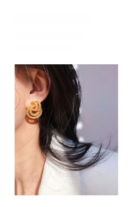Close-up of vintage gold spiral twist earrings worn by model for a trendy aesthetic
