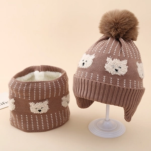 Detail of warm brown knit hat and scarf set with bear embroidery and soft fleece lining