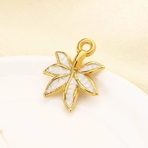 Macro shot of maple leaf pendant in 18K gold plating with white enamel inlay detail