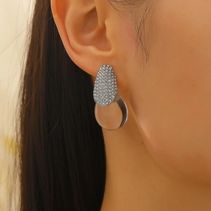 Macro view of teardrop earrings with pavé crystals and transparent resin drop